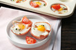 Plate with tasty eggs in ham on table