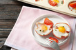 Plate with tasty eggs in ham on table