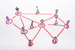 © Wisiel - Miniature business people in conection scheme over white backdrop or background.