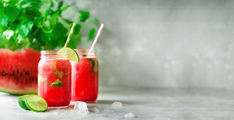 Wall Mural - Fresh red watermelon slice and smoothie in glass jar with straw, ice, mint, lime on light background, copy space