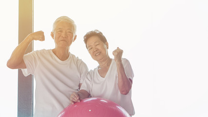 Wall Mural - Happy senior Asian couple have fun with gym yoga ball class