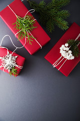 Wall Mural - christmas handmade gift boxes decorated with red paper, green branches and white snowflakes on dark 