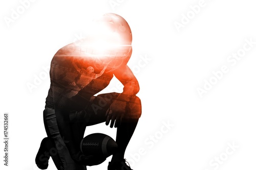 American football player kneeling while holding ball