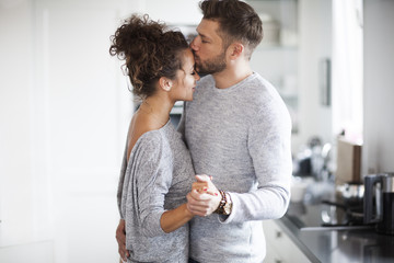 Intimate couple is dancing in the kitchen. Passion in the house.