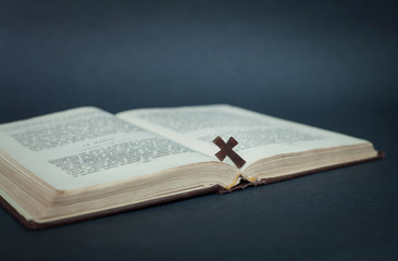 Cross and bible on a blue background.