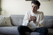 © studiomarquez/Stocksy - Young man thoughtful at home