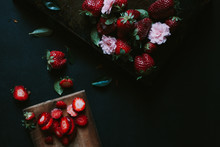 Strawberries And Flowers On A Dark Background