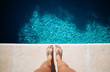 © Susana Ramirez/Stocksy - Feet to the edge of a pool
