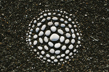 White Stones Arranged In Circular Pattern On Beach