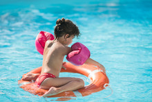Little Girl In A Swimming Pool Floating On A Lifebelt