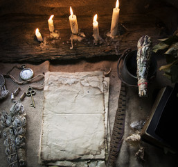 Magic fairytale table in the hut with window to the garden with open ancient book and burning candles