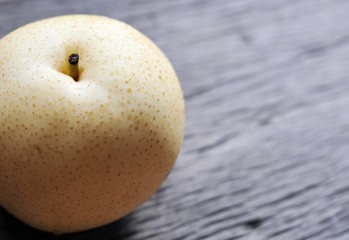 raw organic yellow Asian apple pear on wooden table