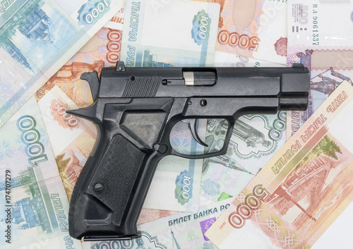 Zdjęcie XXL Czarny pistolet leży na pieniądzach z lufą po prawej