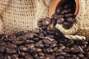 Roasted coffee beans in hemp sacks isolated on white background.