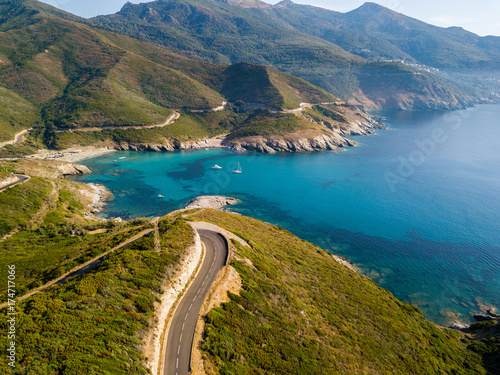 Fotomural Vista aerea della costa della Corsica, strade serpeggianti e calette con mare cristallino
