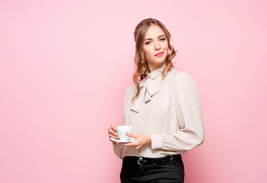 The serious frustrated young beautiful business woman on pink background