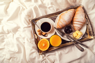 breakfast in bed with coffee and croissants