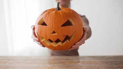 Wall Mural - close up of woman with halloween pumpkin at home