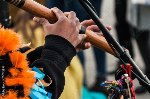 Zdjęcie XXL Ręce muzyka ulicy w garniturze na etnicznym muzycznym instrumencie dętym wykonanym z bambusa.