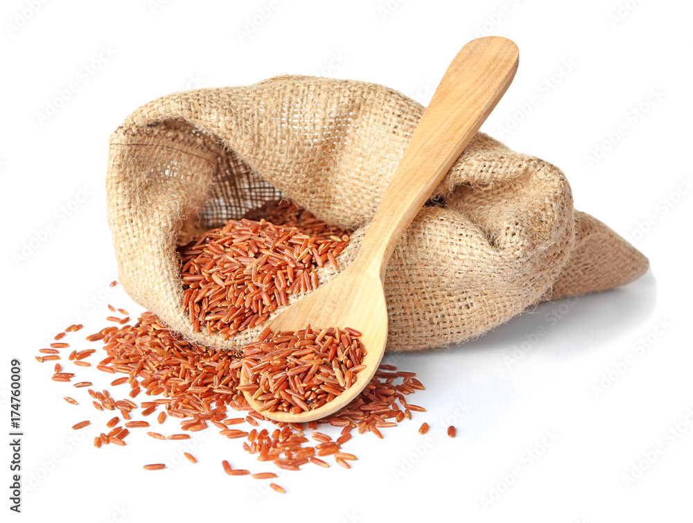 Bag and spoon with red Cargo rice on white background