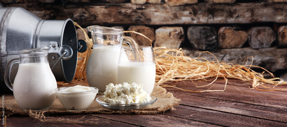 milk products. tasty healthy dairy products on a table on. sour cream in a bowl, cottage cheese bowl, cream in a a bank and milk jar, glass bottle and in a glass - obrazy, fototapety, plakaty 