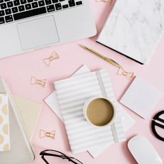 Wall Mural - Flat lay modern workspace with laptop, notebook and stationery on pastel pink background. Top view. Golden style lifestyle concept.