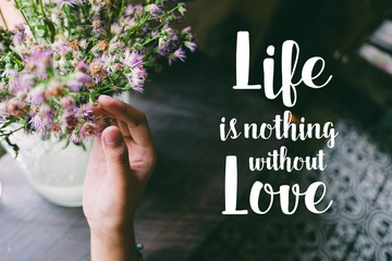 Life quote. Motivation quote on soft background. The hand touching purple flowers. Life is nothing without love.