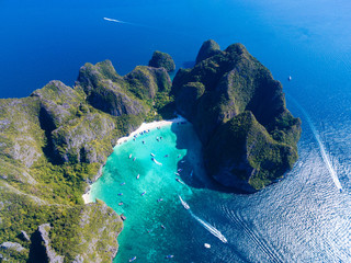 Wall Mural - Top Aerial view of tropical island with limestone rocks, white beach and blue clear water. Maya bay with many boats and speedboats above coral reef. Phi-Phi Islands, Krabi, Thailand.