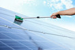 Hand of worker washing solar panels after installation outdoors