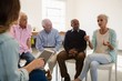© wavebreak3 - Woman gesturing while sitting with friends and instructor during