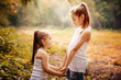 © svetabezu - Childhood, family, friendship and people concept - two happy kids sisters hugging outdoors.