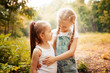 © svetabezu - Childhood, family, friendship and people concept - two happy kids sisters hugging outdoors.