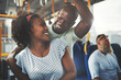 © Flamingo Images - Smiling young African couple standing affectionately together on a bus