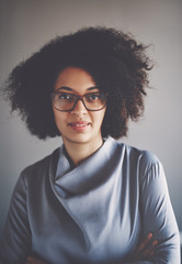 Wall Mural - African businesswoman wearing glasses and standing with her arms crossed