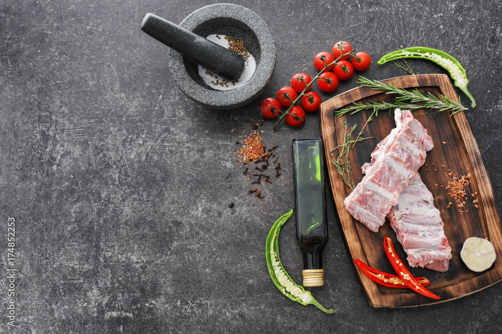 Wooden board with fresh raw meat on table