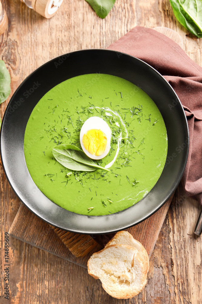 Plate with delicious spinach soup on table