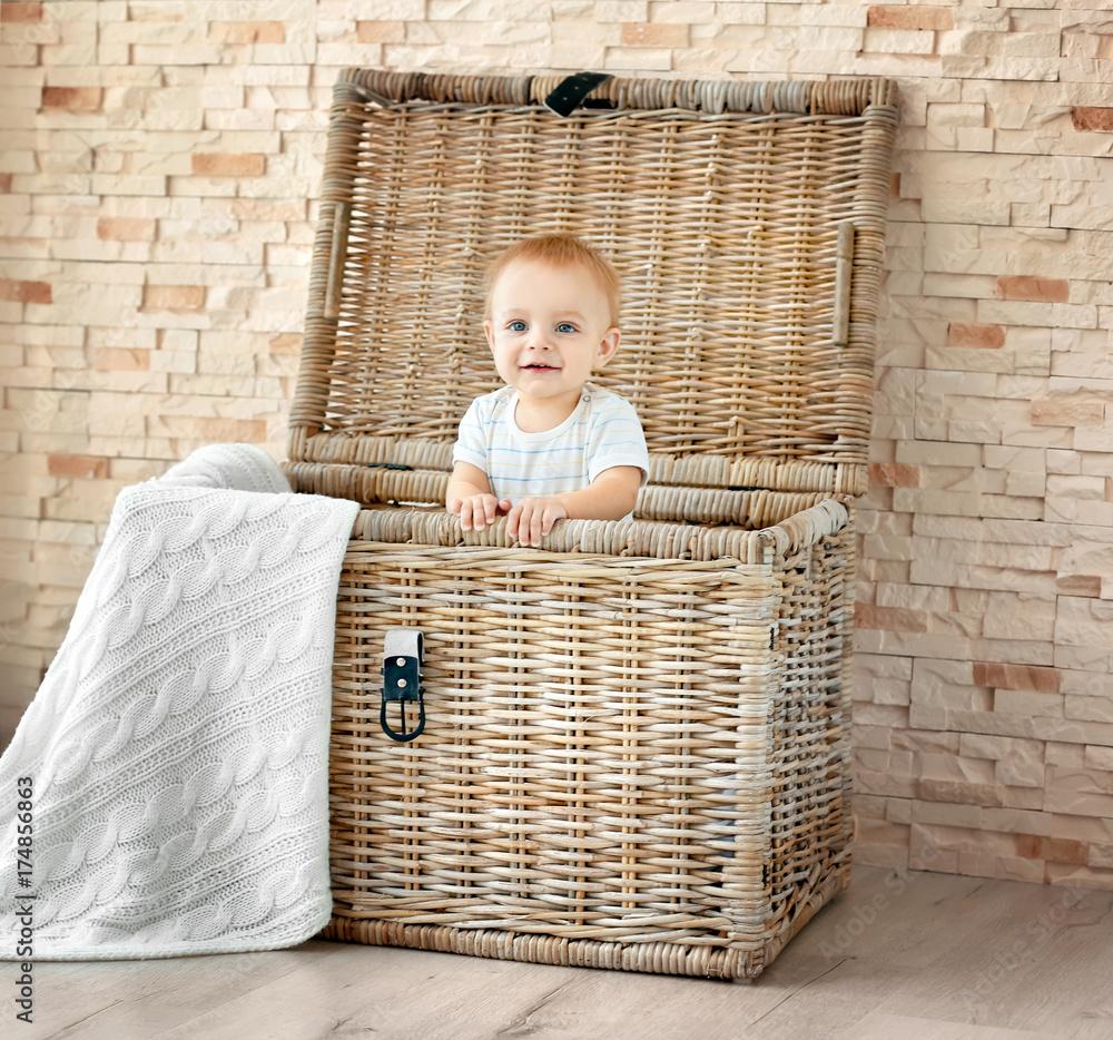 Cute little baby in wicker box at home