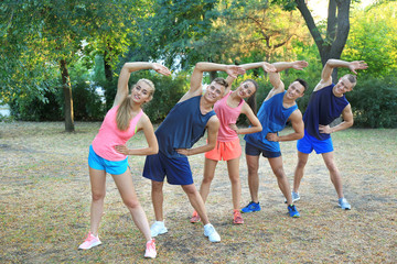 Wall Mural - Group of young people doing exercise outdoor