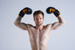 © Anatoliy Karlyuk - Waist up shot of world boxing champion posing in studio with fists raised as sign of victory. Serious attractive athletic young boxer with beard and tattoos showing muscular biceps, ready for fight