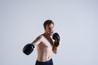© Anatoliy Karlyuk - Studio shot of furious young bearded boxer posing shirtless pushing to his limit while boxing in gym, making angry face, showing strength. People, martial arts, fitness and active lifestyle concept