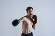 © Anatoliy Karlyuk - Sports, strength and determination concept. Professionald angry kickboxer wearing black trunks and boxing gloves punching air in front of him as if defeating invisible enemy, his look full of fierce