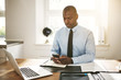 © Flamingo Images - Young businessman reading text messages at his office desk