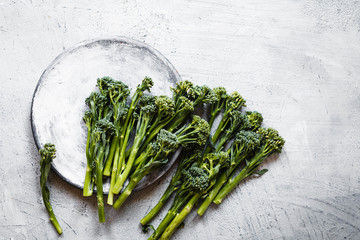 Broccolini, broccoli florets green vegetable broccolini grows baby broccoli vegan food grey table overhead