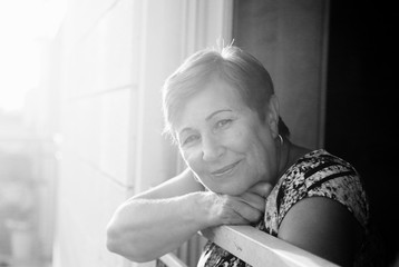 Wall Mural - Portrait of senior woman looking from the balcony