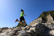woman trail runner running at mountain top