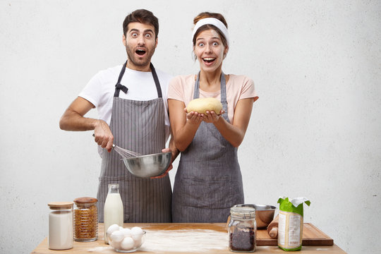 Talented cooks wonder their great achievements in culinary, try new recipe, show dough prepared by hands, bake delicious cake, have excited expressions, don`t believe in success they achieved