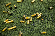 Bullet Shells Ground. Cases Of Bullets Lying On The Floor Of Artificial Grass