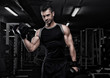 © Pavel Zenyuk - Portrait of sporty healthy strong muscle charismatic happy smiling handsome man bodybuilder hard training workout in well-equipped gym doing biceps exercises with dumbbells in black t-shirt outfit