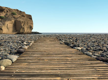 Wooden Walkway On Pebble Stone Beach -