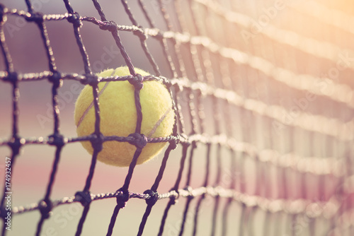 Plakat Tenisowa piłka uderza tenisa sieć przy tenisowym sądem z kopii przestrzenią.